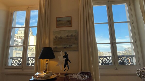 Enjoy a view of the historic cityscape from the comfort of this room, featuring a table, lamp, and decorative art pieces.