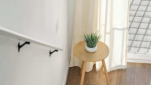 A wooden staircase with a round wooden table and a potted plant beside it.