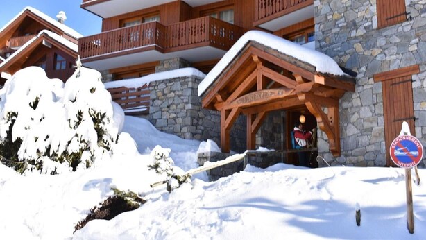A wooden chalet with stone walls and a balcony, surrounded by snow. - 250m from shops, 2nd floor, balcony, tv, ski locker, 75m², Méribel (Méribel - Les Allues)