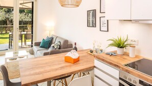 A modern kitchen with a wooden table, white cabinets, and a built-in oven.
