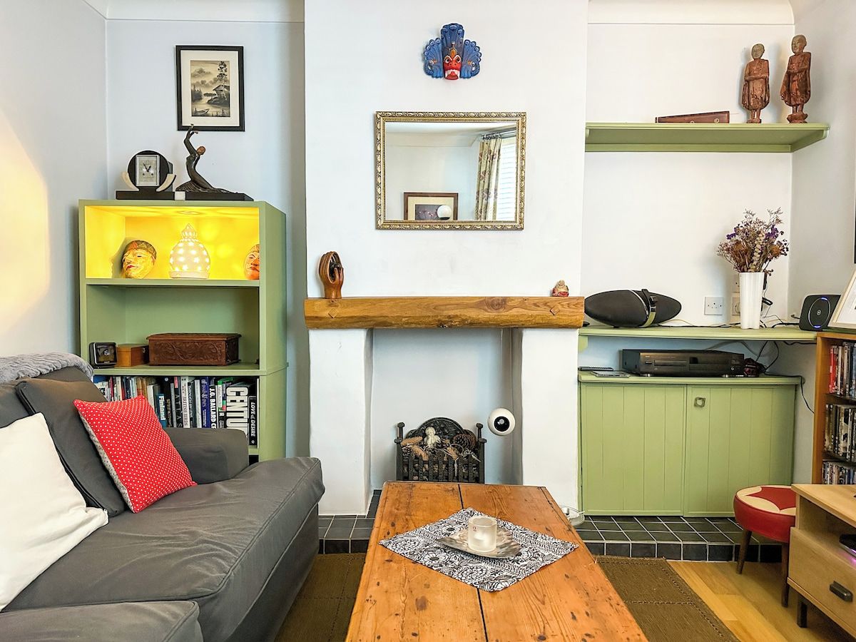 Un salon chaleureux avec un canapé, une table basse, une bibliothèque et une cheminée.