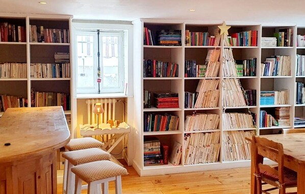 A cozy library with bookshelves, a wooden table, and a star-shaped book display.