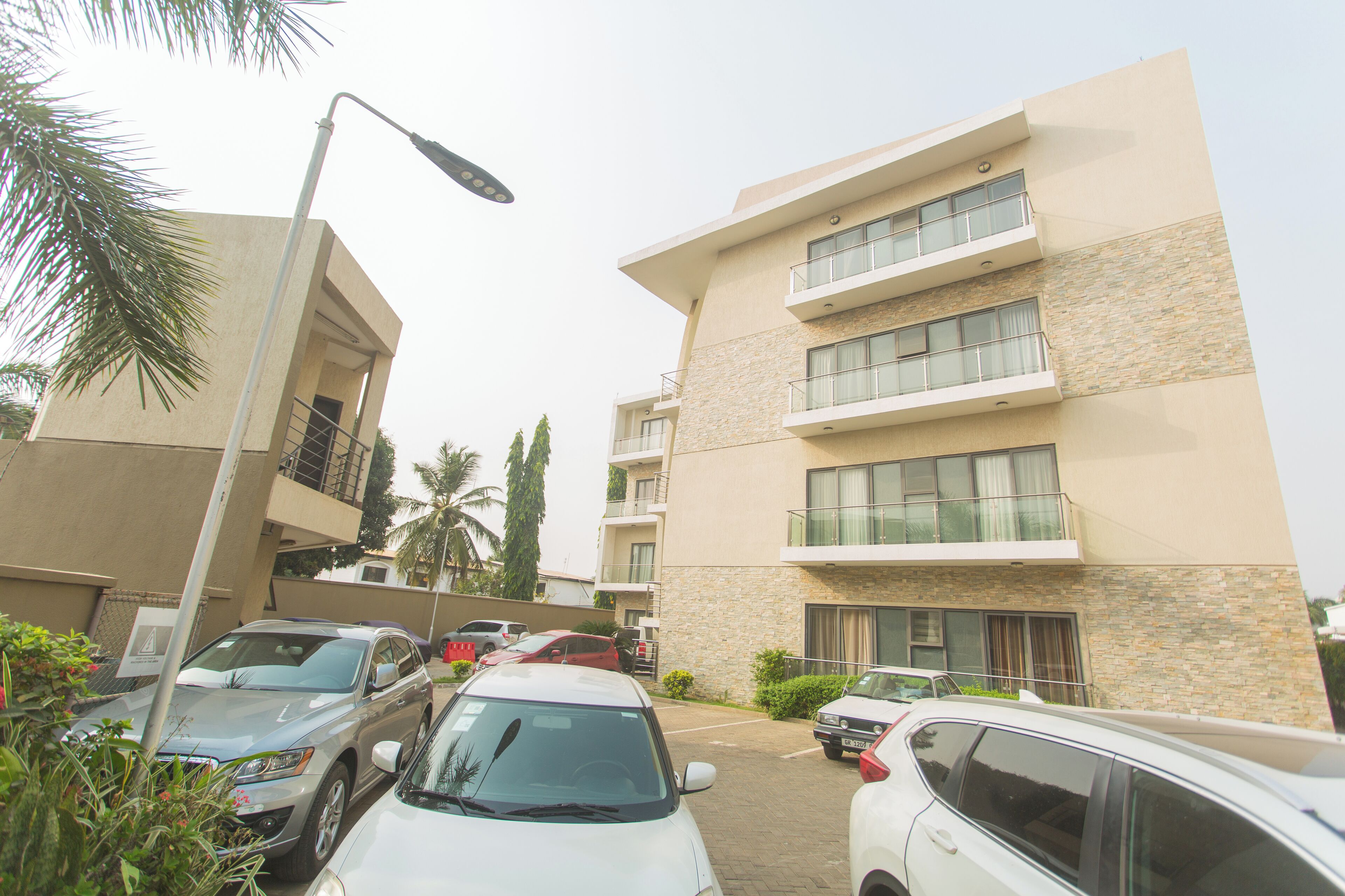 A multi-story building with a parking area in front.
