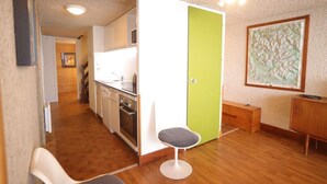 Una cucina compatta con zona pranzo, una porta verde e una mappa appesa al muro.