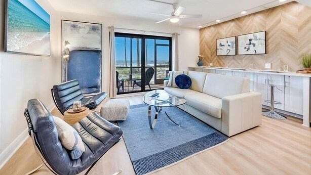 Ein modernes Wohnzimmer mit einer Couch, einem Couchtisch und Blick auf den Strand.