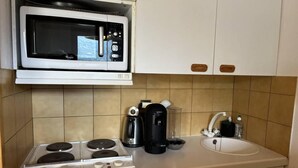 A compact kitchen with a microwave, stove, coffee maker, and sink. - 5m from ski slopes, floor -2, view mountain, balcony, 34m², Méribel-Mottaret (Méribel - Les Allues)
