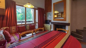 Une pièce confortable avec un lit, un canapé, une table à manger et une cheminée.