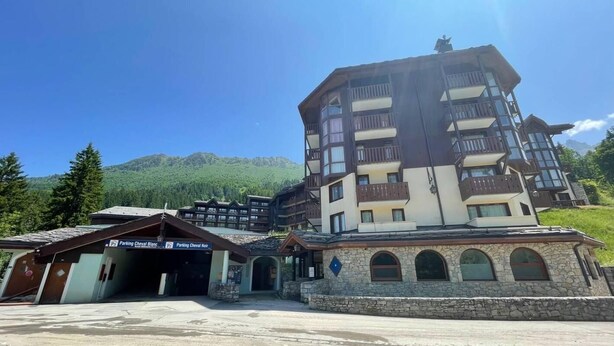 A multi-story hotel with balconies, stone facade, and a mountainous backdrop. - 50m from ski slopes, 11st floor, balcony, ski locker, 45m², Valmorel (Valmorel)