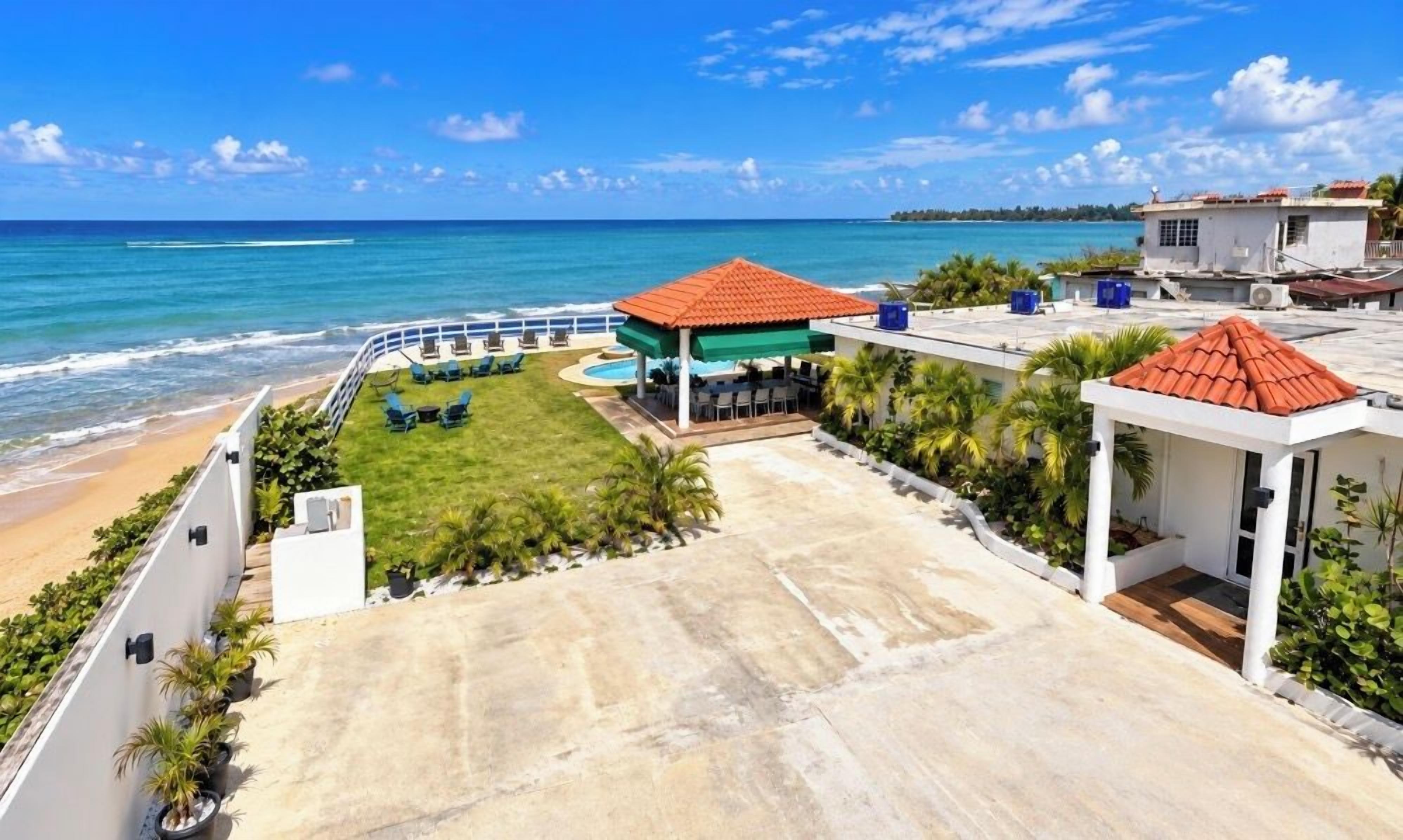 A resort with a pool area, a beach, and a view of the ocean.