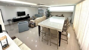 Una sala de estar moderna con sofá, televisión y comedor.