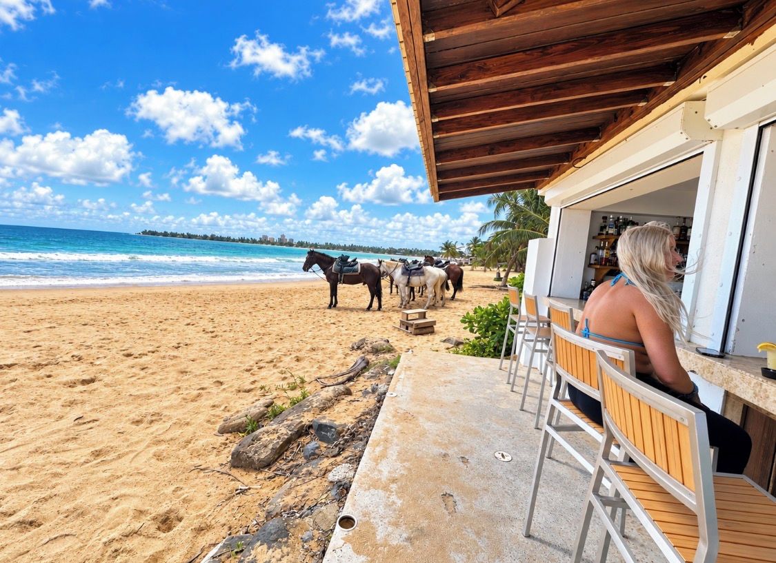A beachside restaurant with outdoor seating, a wooden roof, and a view of the ocean.