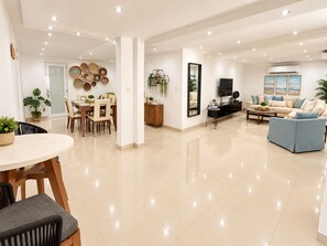 Amplia sala de estar con mesa de comedor, sofás y televisor.