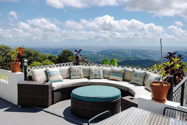 A curved outdoor seating area with a view of a mountainous landscape.
