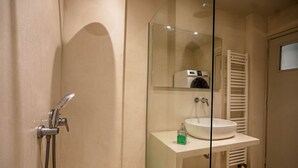 A bathroom with a shower, a sink, and a mirror. - Cozy Corner (Athens)