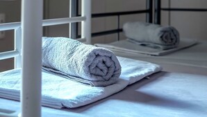 A bunk bed with a rolled towel on the lower bunk and a pillow on the upper bunk. - Cozy Corner (Athens)