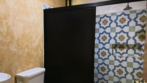 Une salle de bain comprenant des toilettes, un lavabo et un espace douche.