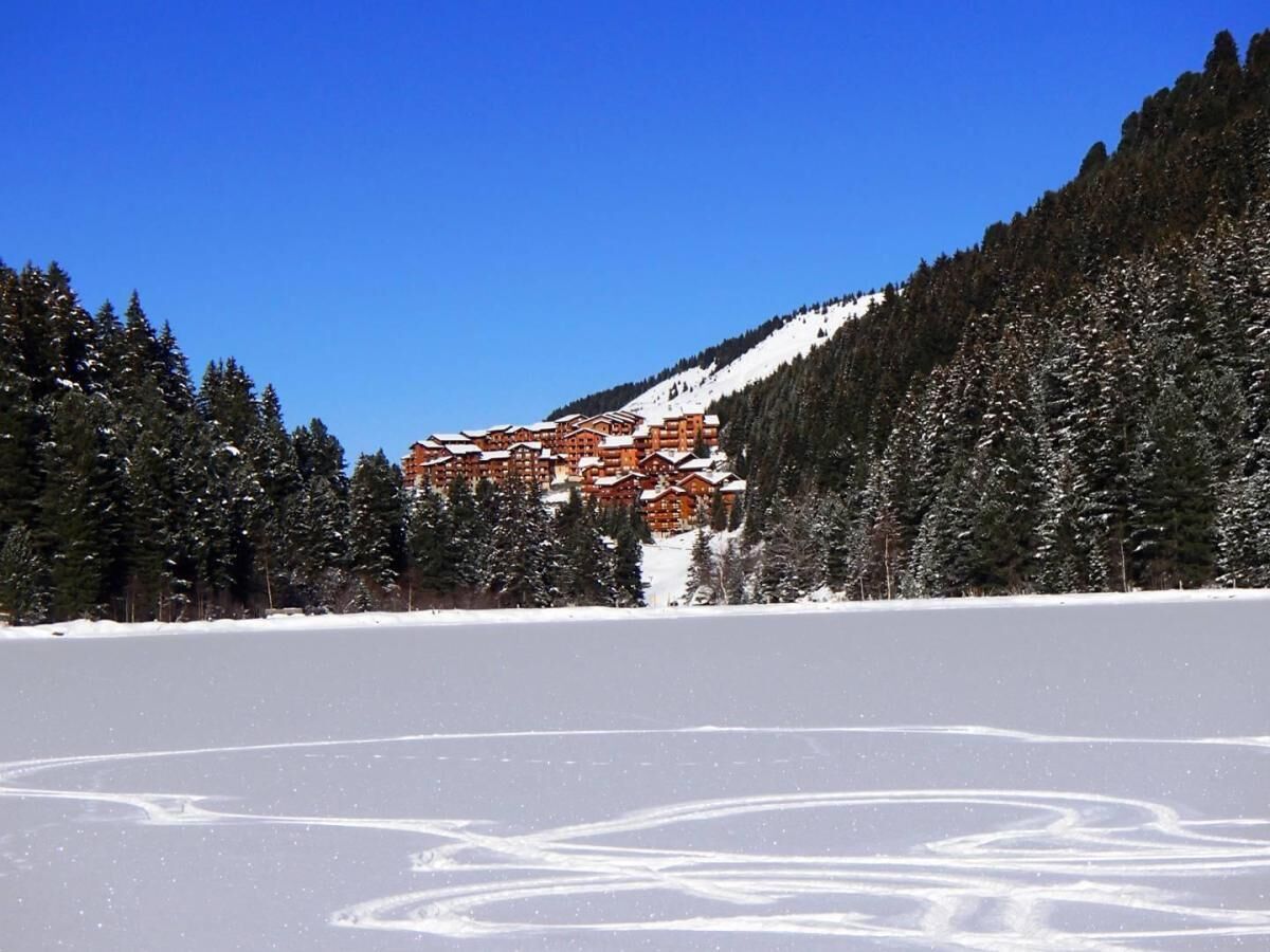 Een besneeuwd landschap met een lodge op de achtergrond.