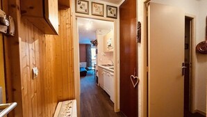Un pasillo con paredes de madera, un banco y una puerta decorada con forma de corazón.