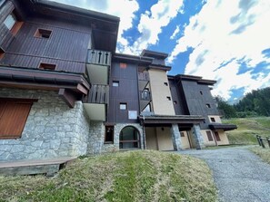 A multi-story building with a stone facade, wooden balconies, and a stone entrance. - 26m from ski slopes, 3rd floor, terrace, tv, ski locker, 35m², Valmorel (Valmorel)