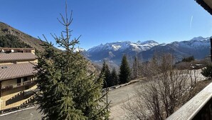 A mountain view with a building in the foreground and snow-capped peaks in the background. - 10m from ski slopes, view mountain, balcony, parking, ski locker, 23m², Auris en Oisans (Auris)