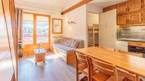 Une pièce chaleureuse avec une table à manger en bois, un canapé et un lit superposé.