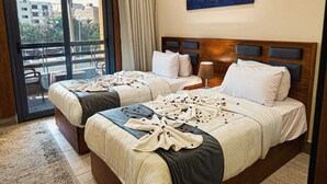 A hotel room with two beds, a balcony, and a city view. - Zahira pyramids view (Giza)