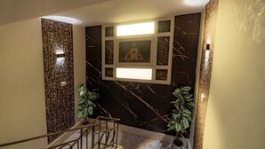 A staircase with a handrail, a wall with a geometric pattern, and two potted plants. - Zahira pyramids view (Giza)