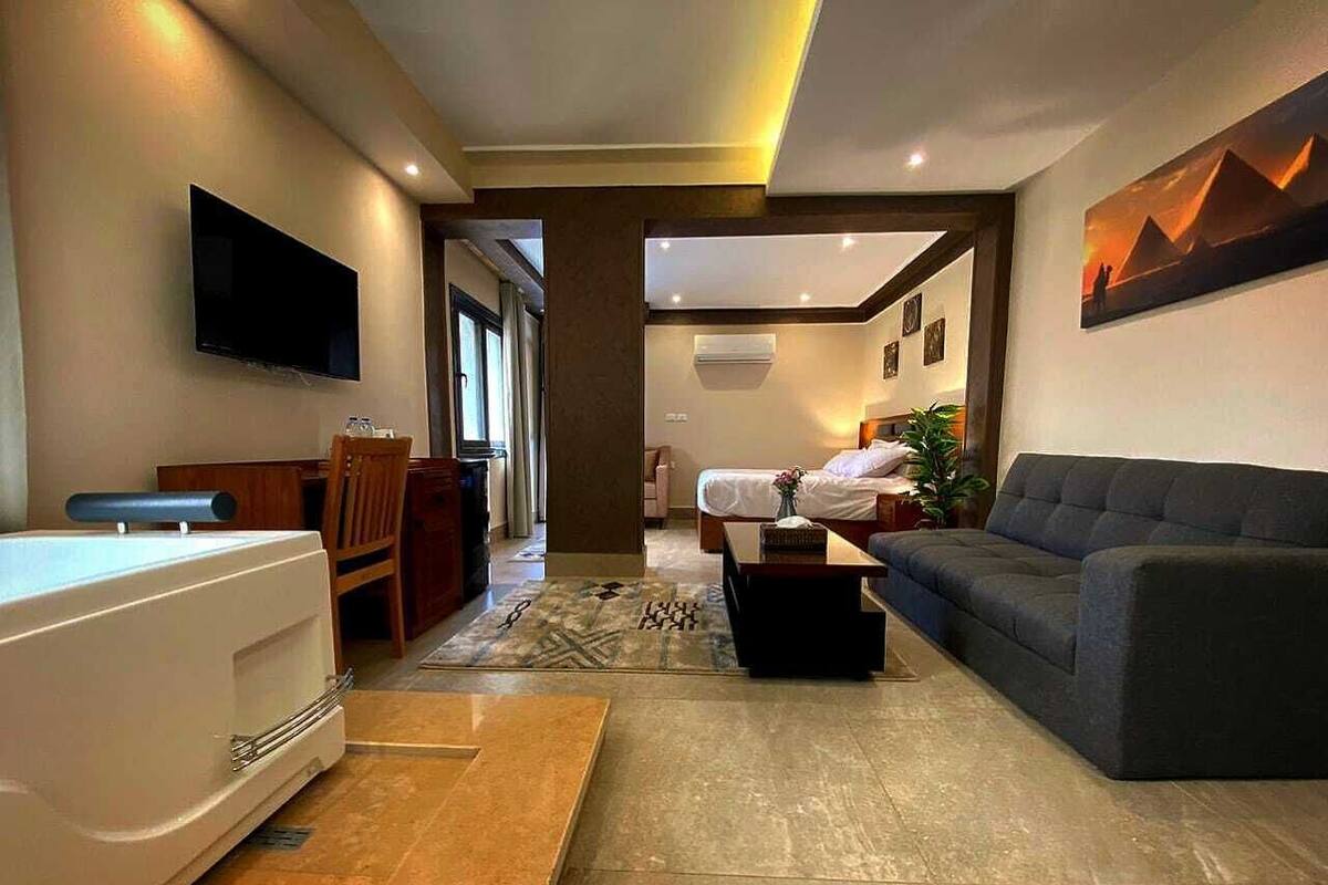 A modern living room with a sofa, a coffee table, a TV, and a bathtub.