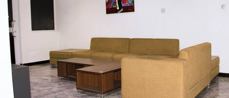 A living room with a sofa, a coffee table, and a painting on the wall.