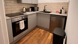 Une cuisine compacte équipée d’une cuisinière, d’un four et d’un lave-vaisselle.