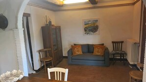 A cozy living room with a sofa, chairs, a dining table, and a fireplace. - Santacaterina, Your oasis of peace overlooking the historic walls of Sansepolcro (Sansepolcro)