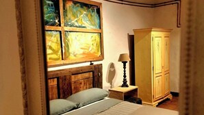 A bedroom with a bed, a wooden headboard, a nightstand, a lamp, a wardrobe, and a painting on the wall. - Santacaterina, Your oasis of peace overlooking the historic walls of Sansepolcro (Sansepolcro)