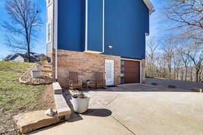 A modern two-story house with a brick facade and blue siding, a front porch with a bench, and a large potted plant. - 1 Mi to Chickamauga Lake: Apartment in Soddy-Daisy (Soddy-Daisy)