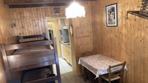A wooden interior with bunk beds, a dining table, and a hanging light fixture. - View mountain, terrace, tv, ski locker, 18m², Le Grand Bornand (Le Grand-Bornand)