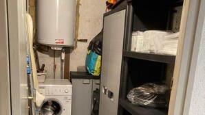 A laundry room with a washing machine, a dryer, and a water heater. There are shelves with various items and a small cabinet. - View mountain, terrace, tv, ski locker, 18m², Le Grand Bornand (Le Grand-Bornand)
