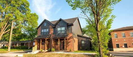 A two-story house with a front porch, a garage, and a driveway.