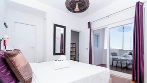 A bedroom with a bed, a bedside lamp, a window, and a view of the outside. - TheHOUSE - Your luxury home (Lisboa)