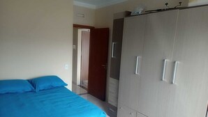 Una camera da letto con un letto, un armadio e una porta che dà su un'altra stanza.