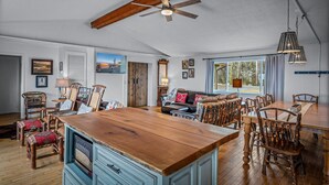 Un'ampia zona giorno con un tavolo da pranzo in legno, un divano e una ventola a soffitto.