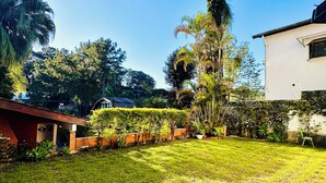 A well-maintained backyard with a lawn, a tall tree, and a brick structure. - Casa de Alto Padrão no Jd Marajoara (São Paulo)