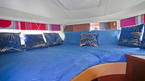 A room with a large bed, blue bedding, and patterned pillows.