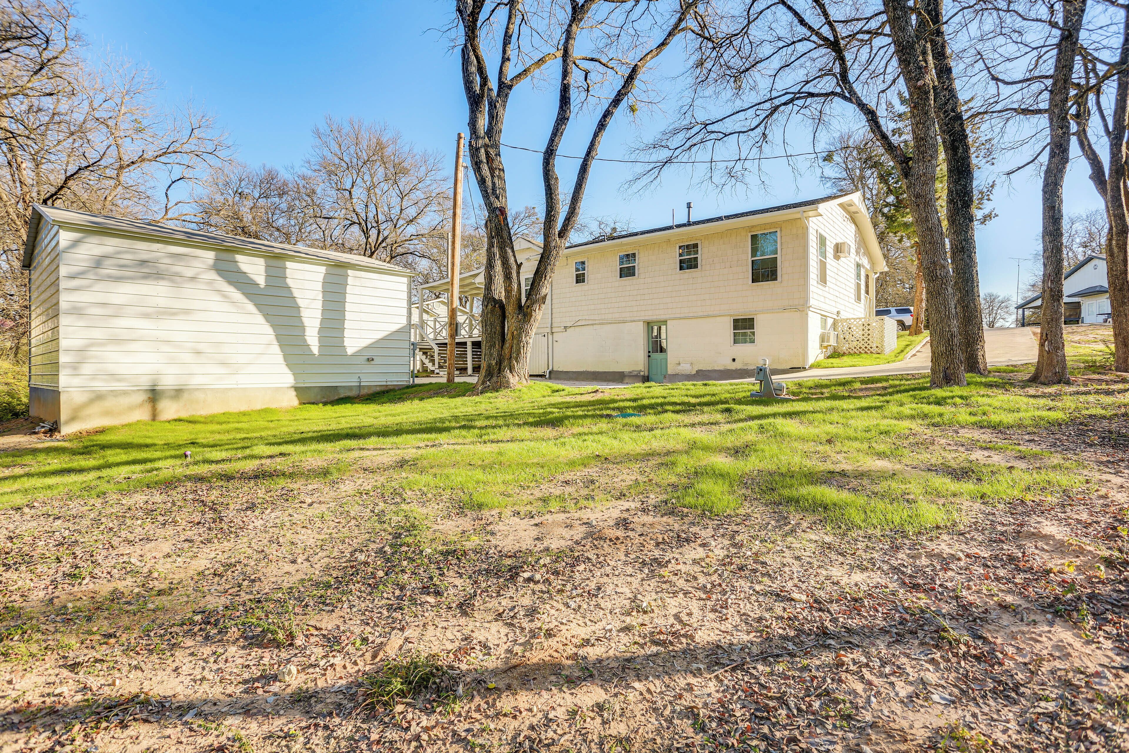 A two-story house with a garage, surrounded by trees and a grassy yard.