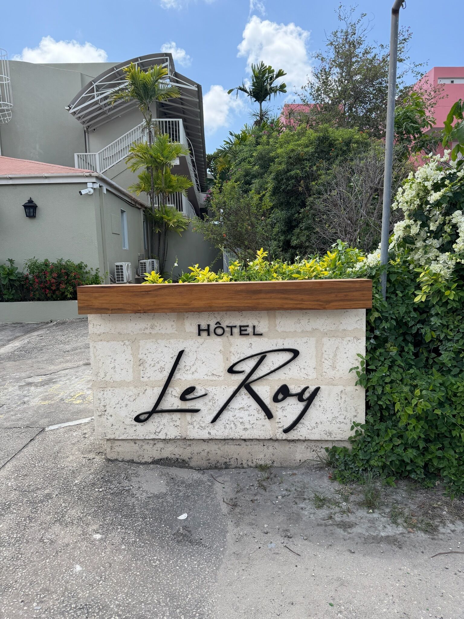Un letrero de hotel con la inscripción 'Hôtel Le Roy' en una pared de piedra.