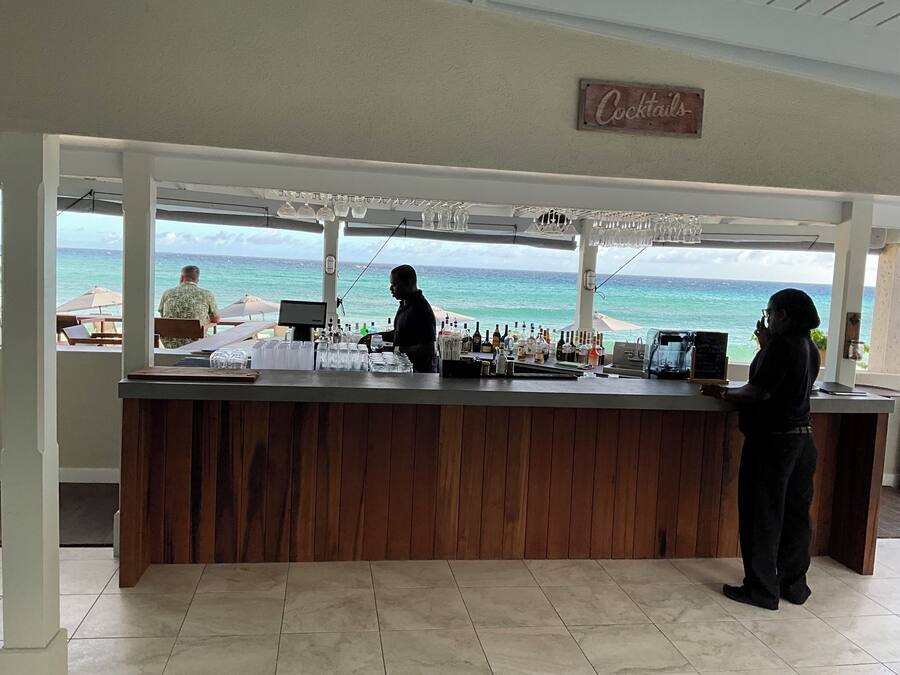 Zona de bar con vistas al océano, un cartel que dice