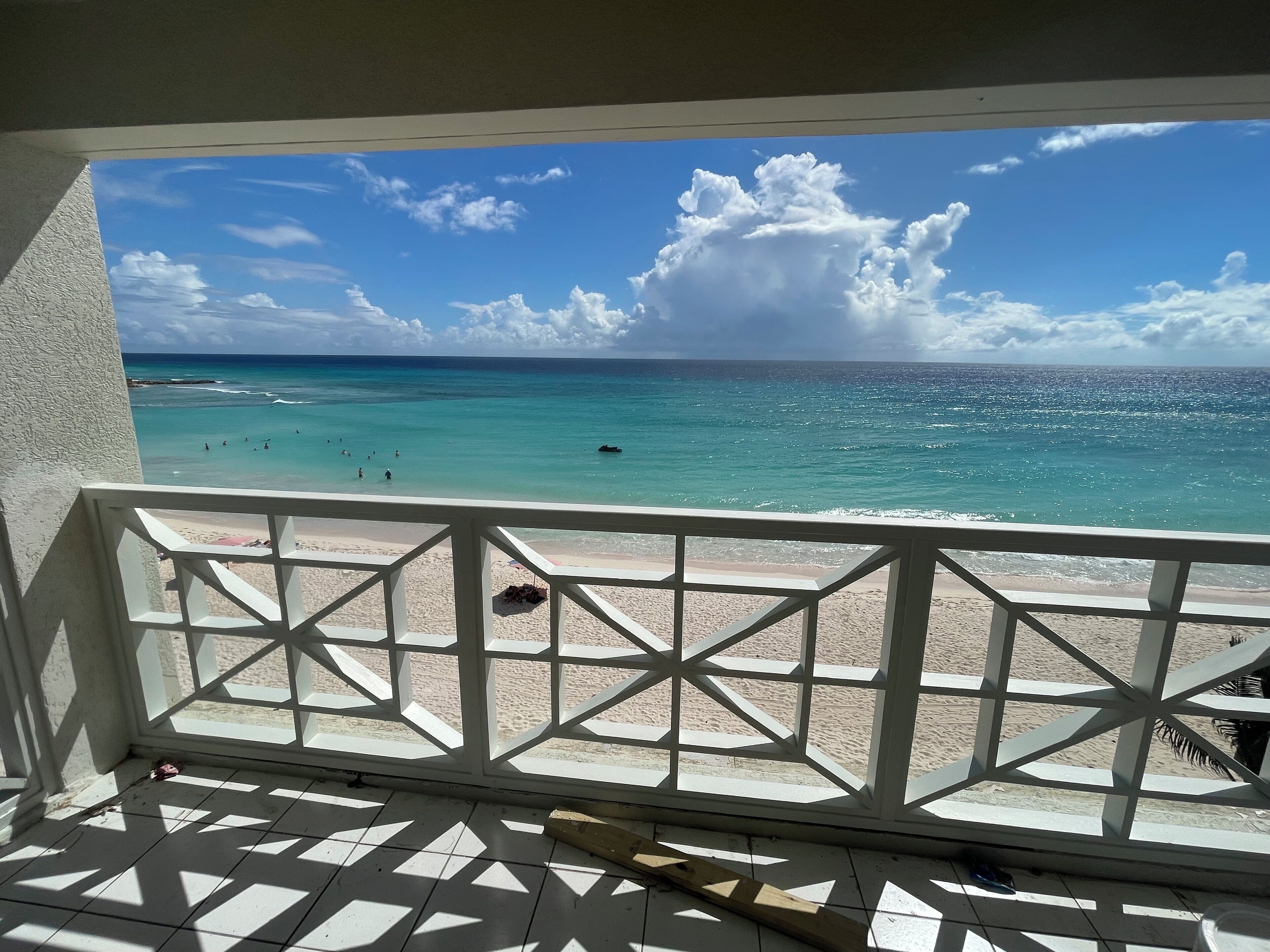 A balcony with a view of a beach and ocean.