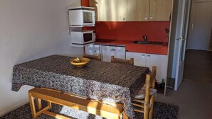A compact kitchen with a dining table, a bench, and a microwave stacked on top of each other. - 1st floor, tv, 52m², Alpe d'Huez (L'Alpe d'Huez)