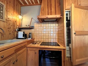 A kitchen with wooden cabinets, a tiled backsplash, a built-in oven, and a dishwasher.