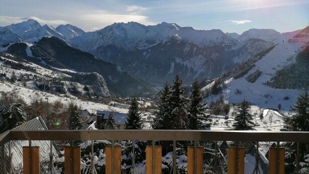 Eine Berglandschaft mit schneebedeckten Gipfeln und blauem Himmel.