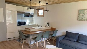 A modern kitchen with white cabinets, a wooden dining table, and four chairs. - 2nd floor, balcony, fireplace or stove, parking, tv, ski locker, 40m², Le Grand Bornand (Le Grand-Bornand)
