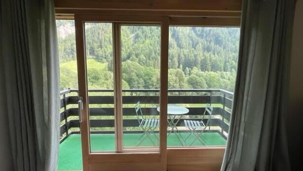 A room with a balcony overlooking a forested area. - 2nd floor, balcony, fireplace or stove, parking, tv, ski locker, 40m², Le Grand Bornand (Le Grand-Bornand)